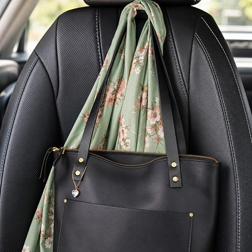 Car headrest hooks holding a tote bag and a scarf