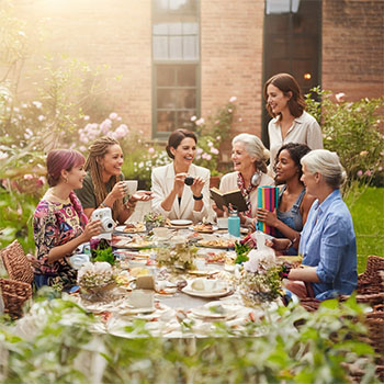 Seven women of differing ages, personalities, and interests enjoying coffee together in a lovely flower garden.